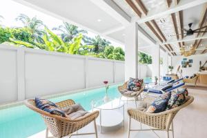 a living room with a pool and chairs and a table at Kokotel Krabi Oasis in Ao Nang Beach