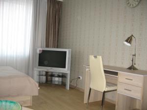 カリーニングラードにあるНа улице Зои Космодемьянскойのデスク、テレビ、ベッドが備わるホテルルームです。