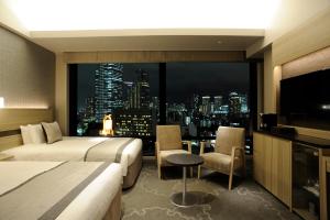 a hotel room with two beds and a large window at Hotel Keihan Tsukiji Ginza Grande in Tokyo