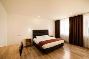ein Schlafzimmer mit einem großen Bett in einem Zimmer in der Unterkunft Biplan Hotel in Daugavpils