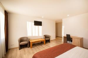 Schlafzimmer mit einem Bett, einem Tisch und Stühlen in der Unterkunft Biplan Hotel in Daugavpils