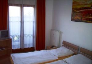 1 Schlafzimmer mit 2 Einzelbetten und einem Fenster in der Unterkunft Picobello Herberge in Görlitz