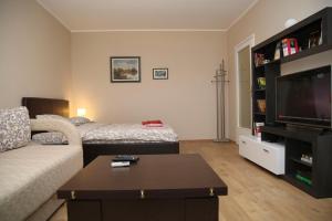 a living room with a couch and a flat screen tv at Havana Beograd Apartment in Belgrade
