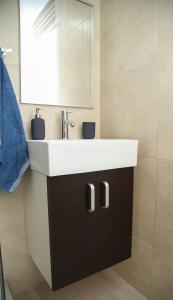 a bathroom with a white sink and a mirror at Havana Beograd Apartment in Belgrade