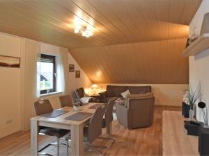 een woonkamer met een tafel en een bank bij Cozy Apartment in Merlsheim with Garden in Nieheim