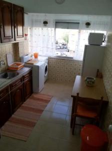 a kitchen with a white refrigerator and a table at Akicity Sintra Easy in Sintra