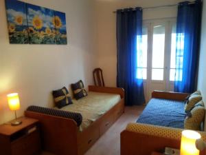 een slaapkamer met een bed, een bank en een raam bij Akicity Sintra Easy in Sintra