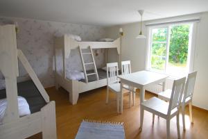a room with two bunk beds and a table and chairs at Tjärö Hotell & Vandrarhem in Trensum