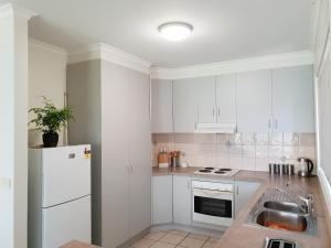 Una cocina blanca con fregadero y refrigerador. en SAN Mateo, en Mildura 6 fotos más