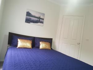 a bedroom with a blue bed with two pillows at SAN Mateo in Mildura