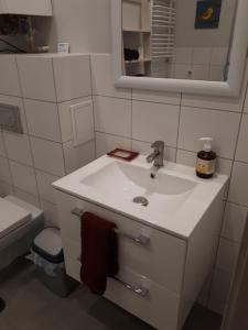 a white bathroom with a sink and a toilet at Apartament Pogodny in Jelenia Góra