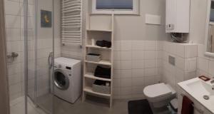 a bathroom with a washing machine in the shower at Apartament Pogodny in Jelenia Góra