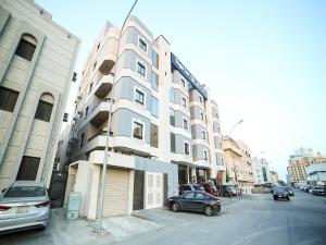 a building on a street with cars parked in front of it at نايت ان للشقق المخدومة in Al Khobar