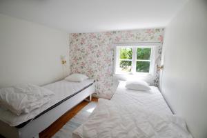 a bedroom with two beds and a window at Tjärö Hotell & Vandrarhem in Trensum