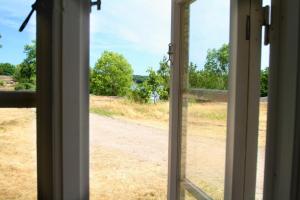an open window with a view of a dirt road at Tjärö Hotell & Vandrarhem in Trensum