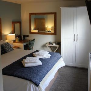 um quarto com uma cama com toalhas em The Pityme Inn em Wadebridge