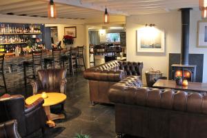 a bar with leather couches and a table and a bar at The Pityme Inn in Wadebridge
