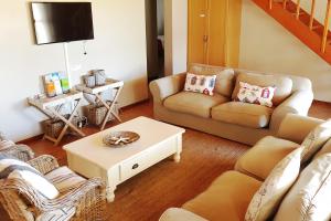 a living room with a couch and a table at Fairway 2 Holiday Home in Langebaan