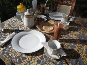 une table avec des assiettes de nourriture et de boissons dessus dans l'établissement River Forest Nest, à Ella