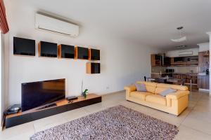 a living room with a couch and a big screen tv at Apartment with Pool in Sliema