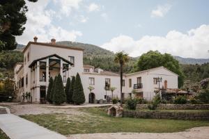a large white house with a palm tree in front of it at Eco Hotel con encanto Masía la Mota B&B in Alcoy