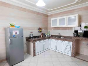 eine Küche mit weißen Schränken und einem Kühlschrank in der Unterkunft Chez Ali Apartments in Essaouira
