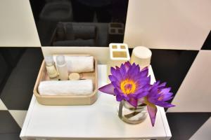 a purple flower in a vase on a white table at BeachMirissa Hotel in Mirissa