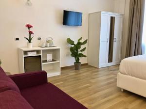 - un salon avec un canapé et une télévision dans l'établissement Residenza Madonna, à Pompéi