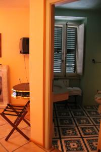 a room with a bathroom with a table and a window at Locanda di Porta Antica in San Benedetto del Tronto