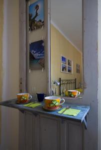 a counter top with two cups and a mirror at B&B la Bitta in Cagliari