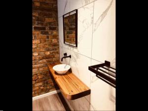 baño con lavabo y pared de ladrillo en Waterfront Apartment en Scarborough