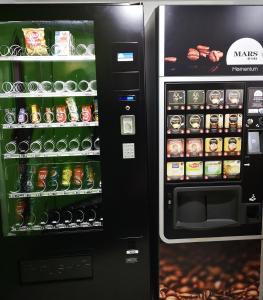 a black vending machine with food and drinks at Lemon Hotel Ch Futuroscope in Châtellerault