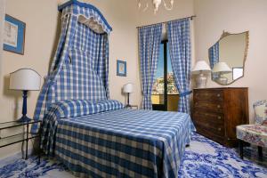 a blue and white bedroom with a bed and a dresser at Palazzo Margherita in Positano