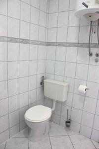 La salle de bains blanche est pourvue de toilettes et d'un lavabo. dans l'établissement Apartments Kaja, à Pag