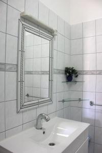 La salle de bains blanche est pourvue d'un lavabo et d'un miroir. dans l'établissement Apartments Kaja, à Pag