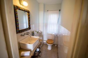 a bathroom with a sink and a toilet and a mirror at Desert Home in Mitzpe Ramon