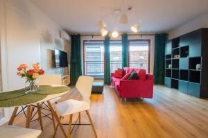 uma sala de estar com um sofá vermelho e uma mesa em Grand Apartments - Apartments SPA Waterlane Island em Gdansk