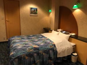 HOTEL Fairy tale 養父店 في Yōka: غرفة فندق بسرير في غرفة