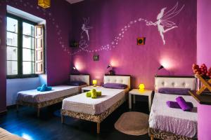 two beds in a room with purple walls at Five Trees in Sliema