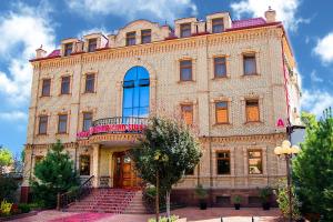 a large brick building with a staircase in front of it at Hotel Grand Samarkand Superior - A in Samarkand