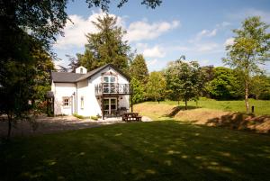 ein weißes Haus mit einem Balkon auf einer Wiese in der Unterkunft Bellfry at Old Boley in Wexford