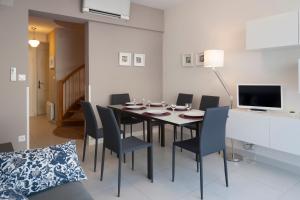 une salle à manger avec une table, des chaises et une télévision dans l'établissement Maison Borrel, à Carcassonne