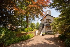 a white house with a staircase leading up to it at Bellfry at Old Boley in Wexford
