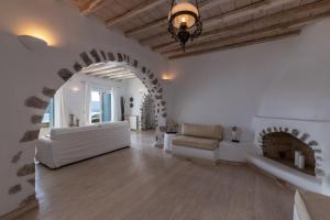 salon z białą kanapą i kominkiem w obiekcie Summer Mood Villas (6 bedroom villa) w mieście Mykonos +28 zdjęć