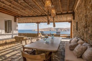 a dining room with a table and a view of the ocean at Summer Mood Villas (6 bedroom villa) in Mikonos