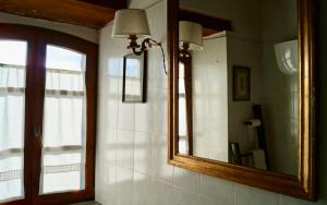 a bathroom with a mirror and a window and a sink at La Petriola Casa Vacanze in Gubbio