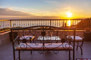 a bed on a balcony with the sunset in the background at 19th Century stone art house in NATURE PARK in Makarska