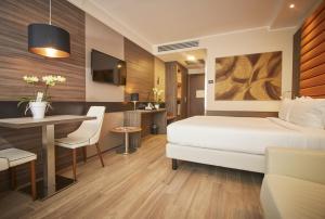 a bedroom with a bed and a table and a desk at iH Hotels Milano Lorenteggio in Milan +47 photos