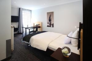 a hotel room with a bed and a desk at Schiller 5 Hotel in Munich