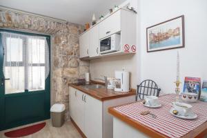 a kitchen with a sink and a counter with a table at Apartments Villa Cambi in Split